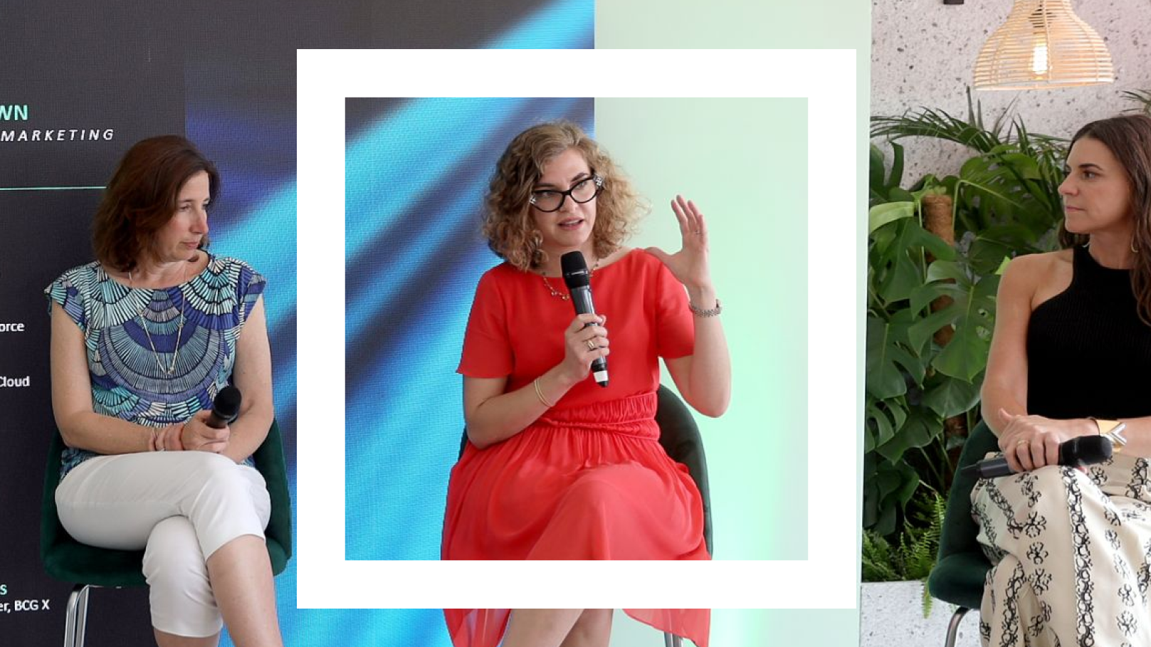 A Polaroid-style photograph captures a lively panel discussion featuring three women seated on a stage. The woman in the center, wearing a bright red dress and glasses, is holding a microphone and gesturing with her hand as she speaks. To her left, a woman in a blue patterned top and white pants is also holding a microphone and listening attentively. To her right, another woman in a black top and patterned skirt is engaged in the conversation. The backdrop includes a mix of abstract blue lighting and greenery, along with a modern hanging light fixture, creating a dynamic and professional atmosphere.