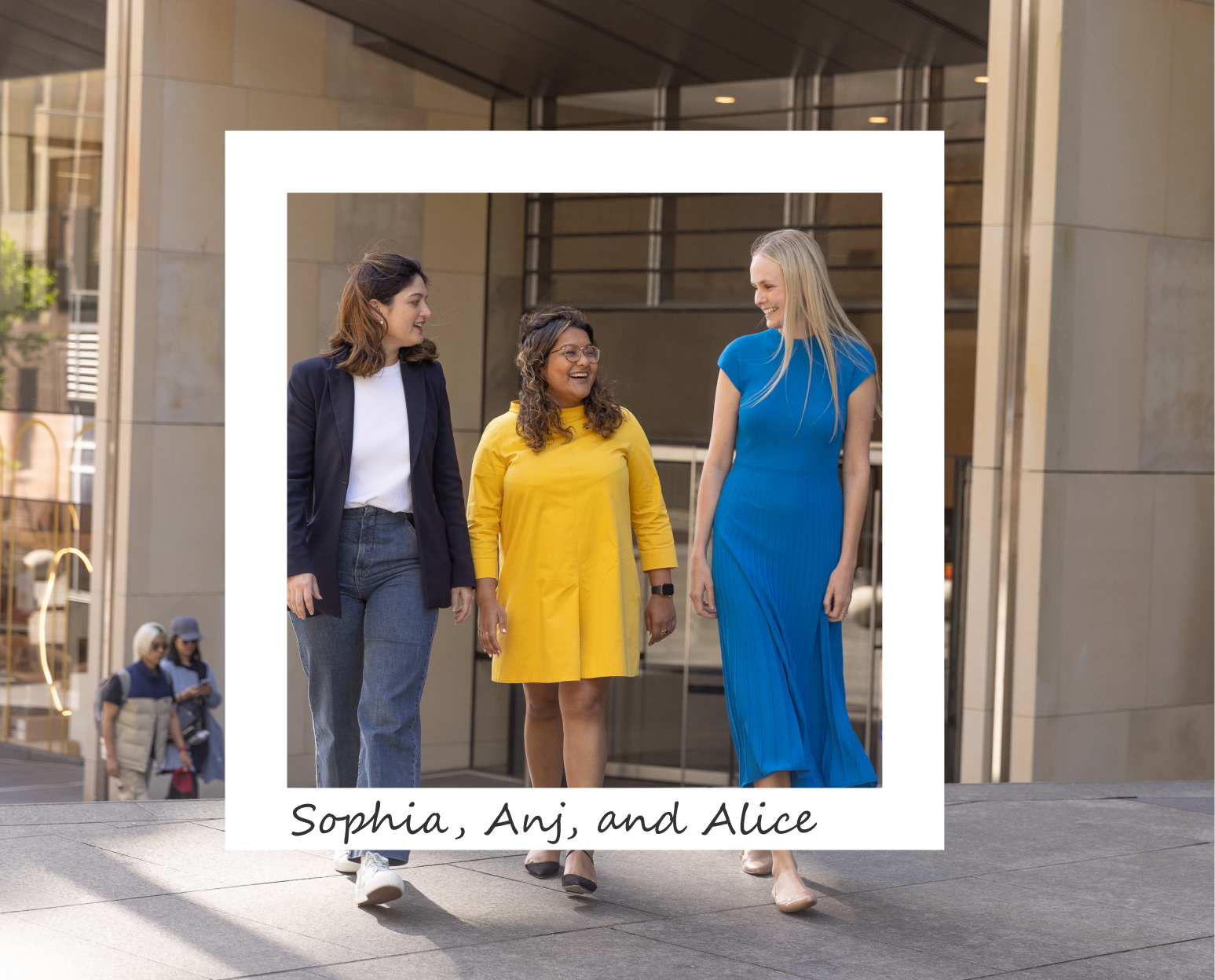 Three women are walking in front of an office building. The woman on the left is in dark blue jeans, a navy blazer, and a white t shirt. The woman in the middle has curly brown hair, is wearing glasses and a yellow, long sleeved mini dress. The woman on the right has blond hair and is wearing a bright blue maxi dress. A white square frame is centered over the women. At the bottom of the frame reads 'Sophia, Anj, and Alice'.
